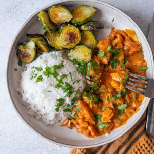 assiette végétarienne composée de tofu sauce coco et curry, de riz et de légumes