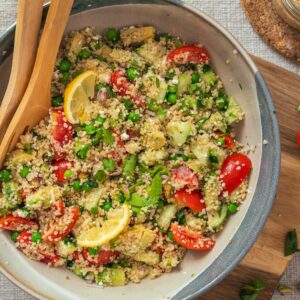 plat de taboulé maison réalisé avec des petits pois, de la menthe, de la feta, des tomates, des pistaches